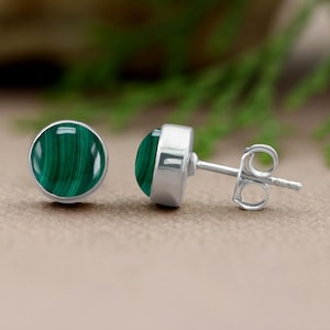 May include: A pair of silver stud earrings with round green malachite stones.