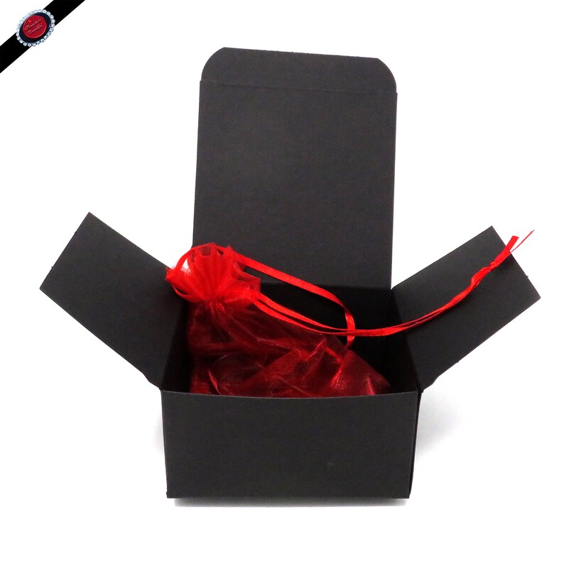May include: A black gift box with a red organza bag inside. The box is open and the bag is visible.
