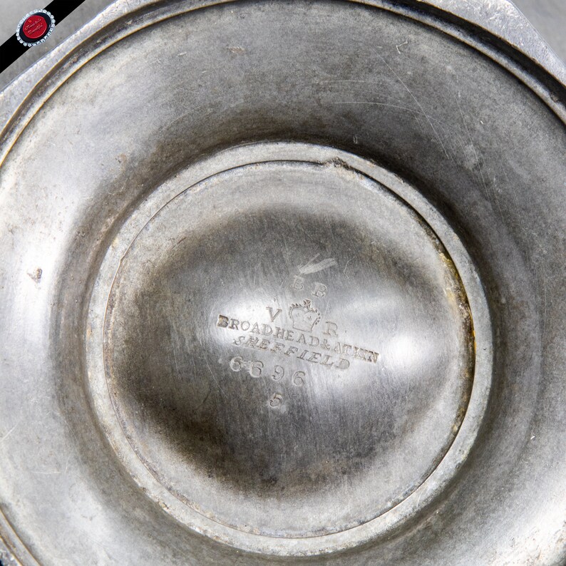 May include: Close-up of the bottom of a silver pitcher with the inscription "V.R. Broadhead & Atkinson Sheffield 6696"