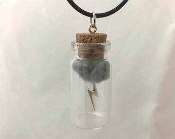 Collar o llavero con diseño de rayo en una botella