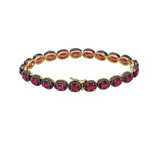 Op de afbeelding: Een gouden armband met ovale robijn-edelstenen die zijn gezet in een halo van zwarte diamanten. De armband heeft een sluiting.