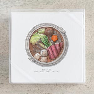 Pode incluir: Ilustração em aquarela de sukiyaki, um prato japonês de panela quente, com carne bovina, vegetais e tofu em uma panela redonda. O prato é apresentado em uma caixa de plástico transparente. O texto "sukiyaki" está abaixo.