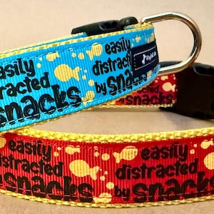 Peut inclure: Deux colliers pour chien avec un fond jaune et bleu et un fond rouge et jaune. Les deux colliers ont le texte "easily distracted by snacks" imprimé dessus. Les colliers sont faits d'un matériau en nylon durable et sont dotés d'une boucle en métal.