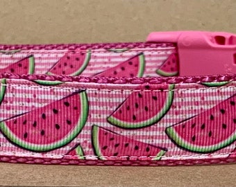 May include: Pink dog collar with a watermelon print. The collar has a pink buckle and a silver D-ring.