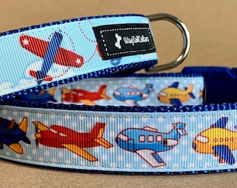 Peut inclure: Deux colliers pour chien bleu et blanc avec un motif d'avion bleu. Les colliers ont une boucle bleue et un anneau en D argenté. Les colliers sont fabriqués par "Top Dog Collar".