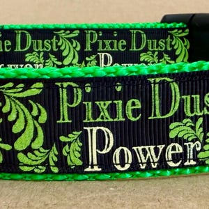 May include: Black and green dog collar with the text "Pixie Dust Power" repeated on the collar.