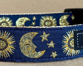 May include: A navy blue dog collar with a gold sun and moon pattern and the text "WagTail Collars" on a black tag.
