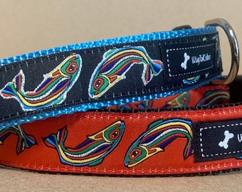 May include: Two dog collars with a black background and colorful fish designs. The top collar is blue with a black label that says "WagTailCollars". The bottom collar is red with a black label that says "WagTailCollars".