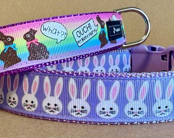 May include: Two dog collars. One is purple with white bunny faces. The other is rainbow-colored with chocolate bunny graphics and the text "OUCH! MY BUTT HURTS" and "WHAT?!"