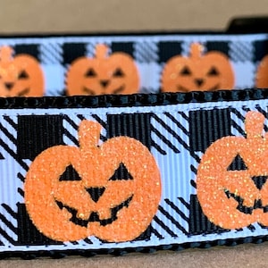 Op de afbeelding: Zwart-wit geblokt hondenhalsband met oranje glitter pompoenontwerpen.