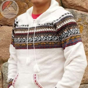Peut inclure: Pull à capuche blanc avec un motif géométrique coloré sur le haut de la poitrine, les manches et les bords des poches. Le pull a une poche avant et un cordon de serrage avec des pompons. Le logo "PERUOUR LIFE" est en haut à gauche.