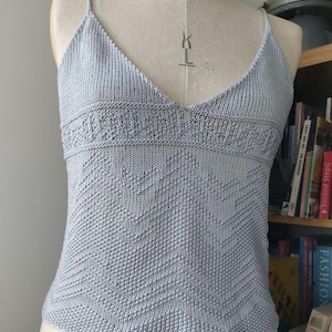 Peut inclure: Un débardeur en tricot bleu clair avec un col en V et un motif géométrique.