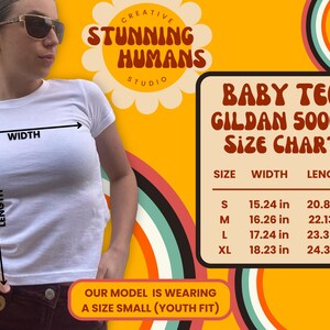 May include: A white baby tee shirt with a size chart showing measurements in inches. The chart includes sizes S, M, L, and XL. The text "Baby Tee Gildan 5000B Size Chart" is displayed in red and white.