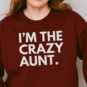 May include: Burgundy sweatshirt with white text that reads "I'm the crazy aunt."