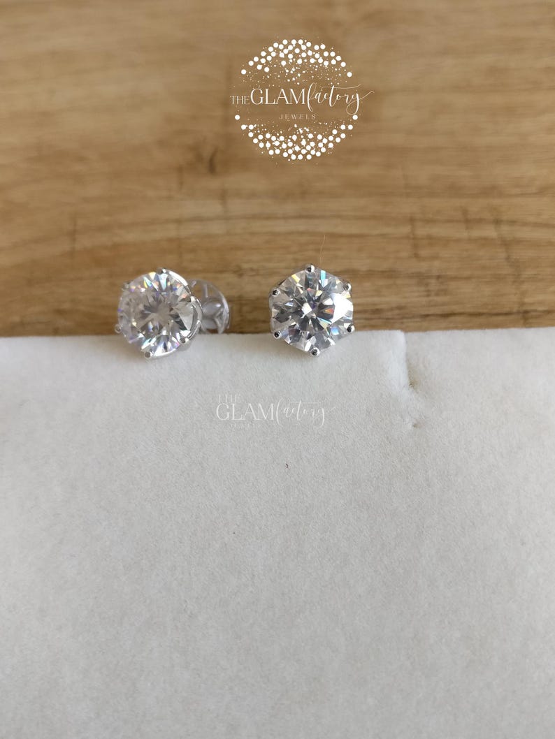 May include: A pair of silver stud earrings with clear round cubic zirconia stones.