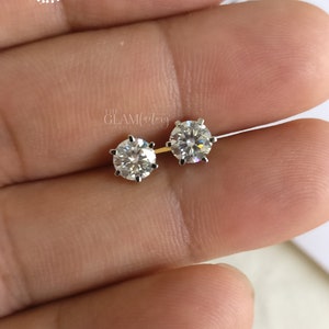 Pode incluir: Um par de brincos de pressão de prata com pedras redondas de zircônia cúbica transparentes.