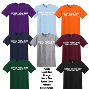 May include: A collection of short-sleeved t-shirts in various colors, including purple, light blue, orange, navy blue, sports grey, maroon, forest green, and black. Each shirt features the text "CUSTOM POSTAL SHIRT ADD LOGO/TEXT".