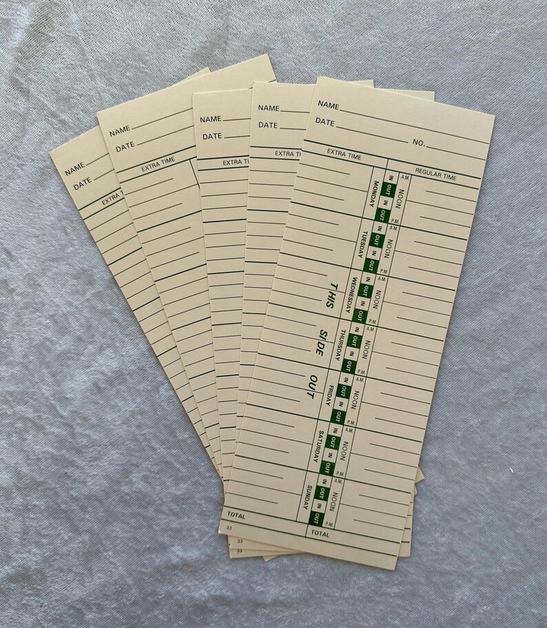 May include: A stack of vintage time cards, each with lines for name, date, and time entries. The cards are a light beige color with green and black printed text. The cards are fanned out, showing the details of the timekeeping layout.
