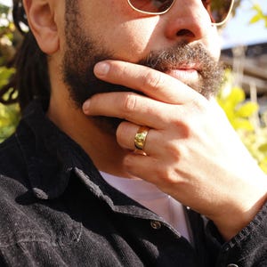 Op de afbeelding: Een gouden bandring met een getextureerd oppervlak.