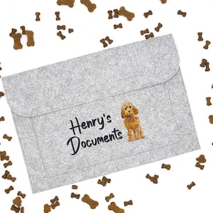 May include: A grey felt envelope with a dog illustration and the text "Henry's Documents" printed on the front.