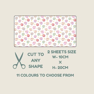 May include: A rectangular sheet featuring a repeating pattern of small cartoon sheep in pastel pink, blue, purple, and grey colors on a white background with yellow dots. Text reads: CUT TO ANY SHAPE, 2 SHEETS SIZE W- 10CM X H- 20CM, 11 COLOURS TO CHOOSE FROM.