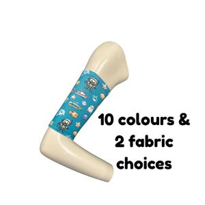 Puede incluir: Una funda para empuñadura de muleta en forma de L de color beige con una manga de tela azul claro que presenta un patrón repetitivo de buceadores, criaturas marinas y barcos. El texto 10 colours & 2 fabric choices aparece en negro al lado.