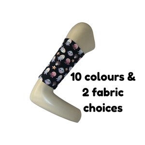 Puede incluir: Una manga de tela negra con un patrón repetitivo de medusas y estrellas de mar coloridas. El texto 10 colours & 2 fabric choices está impreso en negro junto a la manga. La manga se muestra sobre un brazo de maniquí de color beige.