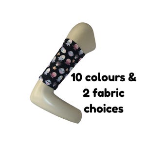 Puede incluir: Una manga de tela negra con un patrón repetitivo de medusas y estrellas de mar coloridas. El texto 10 colours & 2 fabric choices está impreso en negro junto a la manga. La manga se muestra sobre un brazo de maniquí de color beige.