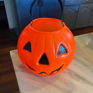Scary ghost with halloween candy bucket and glowing Jack o lantern