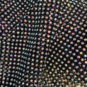 May include: Black fabric with a pattern of iridescent rhinestones.