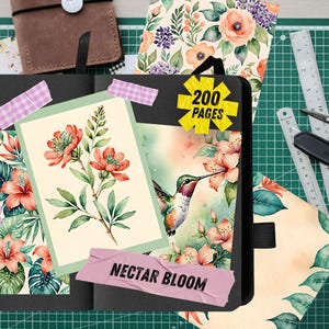 Pu&ograve; includere: Un diario nero con un design floreale, con un colibr&igrave; e la scritta "Nectar Bloom". Il diario include un adesivo che dice "200 pagine". Sono visibili anche altri articoli di cancelleria, tra cui un taccuino in pelle marrone, righelli e forbici.