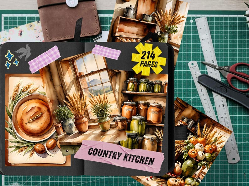 May include: A black journal open to pages featuring illustrations of a country kitchen with jars, wheat, and a window. A yellow starburst graphic reads 214 PAGES and a pink tape strip reads COUNTRY KITCHEN. The journal is on a green cutting mat.