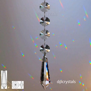 Op de afbeelding: Een kristallen kroonluchterprisma met een traanvormige hanger die hangt aan een ketting van achthoekige kristallen. Het prisma werpt regenbogen op het plafond.