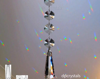 Puede incluir: Un prisma de araña de cristal con un colgante en forma de lágrima que cuelga de una cadena de cristales octogonales. El prisma proyecta arcoíris en el techo.