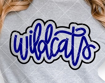 May include: A light gray sweatshirt with the word "wildcats" in blue script with a black outline. The text is centered on the chest. The bottom of the image has the text "The Blank Pineapple" and "SVG PNG DXF".