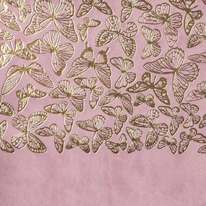 May include: Pink background with a pattern of gold foil butterflies. The butterflies are of various sizes and shapes.