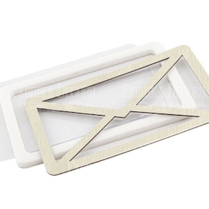 May include: A white wooden envelope frame with a white background. The frame is made of two pieces, one that fits inside the other. The frame is perfect for displaying photos or other small items.