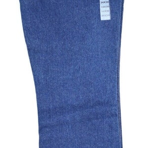 May include: A pair of blue denim jeans with a yellow and brown label that says "Boot Jean Regular Fit Wrangler". The label also has a picture of a man wearing the jeans. The jeans are size 34x30.