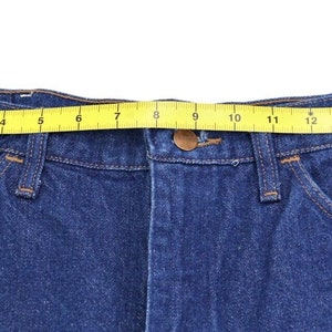 May include: Blue denim jeans with a yellow measuring tape around the waist. The tape measures 16 inches.