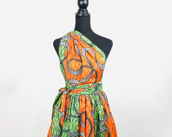 May include: A one-shoulder wrap dress with a green and orange print featuring a swirling pattern. The dress has a tie at the waist.