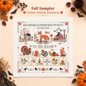 May include: A Fall Sampler cross stitch pattern featuring an alphabet, numbers, a fox, a turkey, a squirrel, a barn, and pumpkins. The text reads Fall Sampler Cross Stitch Pattern, TIS THE SEASON, and GRATEFUL. The design includes autumn motifs.