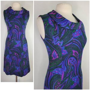 Puede incluir: Un vestido sin mangas con cuello de pico y un estampado paisley en espiral en tonos de morado, azul, verde y negro.