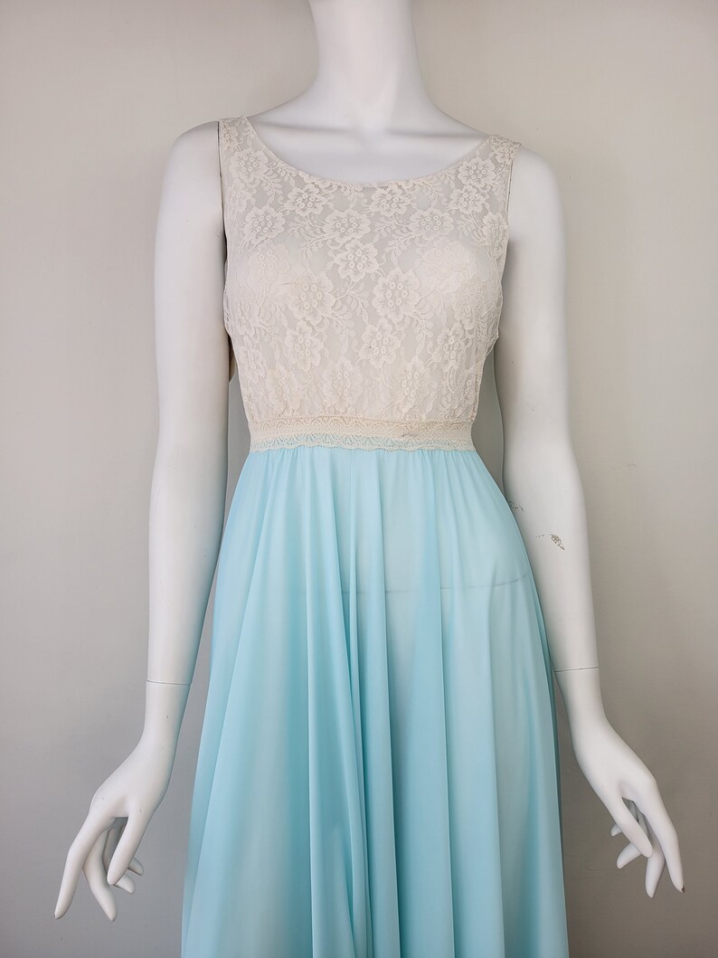 May include: A light blue sleeveless nightgown with a white lace bodice. The gown has a gathered skirt and a fitted bodice.
