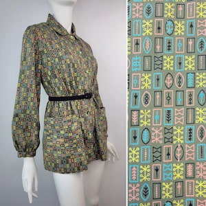May include: A vintage-style button-down shirt dress with a geometric pattern in shades of green, yellow, pink, and blue. The dress features long sleeves, a black belt, and pockets. The fabric swatch shows a close-up of the pattern.
