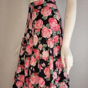 May include: A black maxi skirt with a pink and green floral print. The skirt has a tiered design and a ruffled hem.