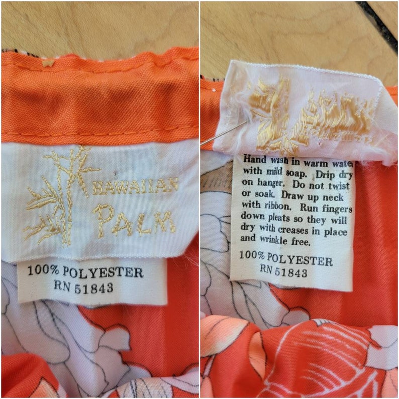 以下が含まれることがあります： オレンジと白の花柄プリントのヴィンテージ衣類のクローズアップ。ラベルには竹の刺繍が施された「HAWAIIAN PALM」と書かれています。お手入れ方法と生地の組成（ポリエステル100％）も表示されています。