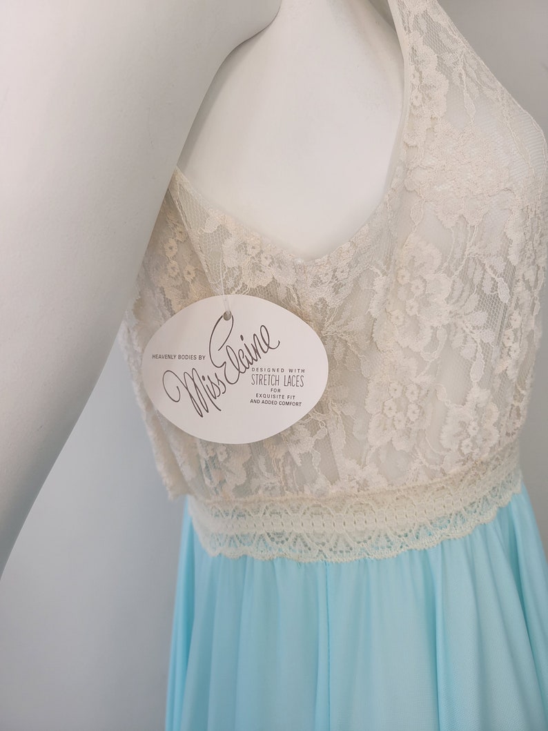 May include: A light blue and white lace nightgown with a white tag that reads "Heavenly Bodies by Miss Elaine Designed with Stretch Laces for Exquisite Fit and Added Comfort".