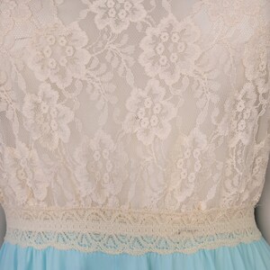 May include: A light blue dress with a white lace bodice and a lace trim around the waist.