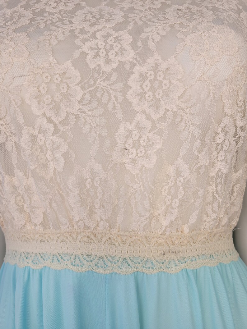 May include: A light blue dress with a white lace bodice and a lace trim around the waist.