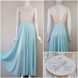 May include: A light blue maxi-length nightgown with a white lace bodice. The gown is designed with stretch laces for an exquisite fit and added comfort. The label reads "Heavenly Bodies by Miss Elaine".